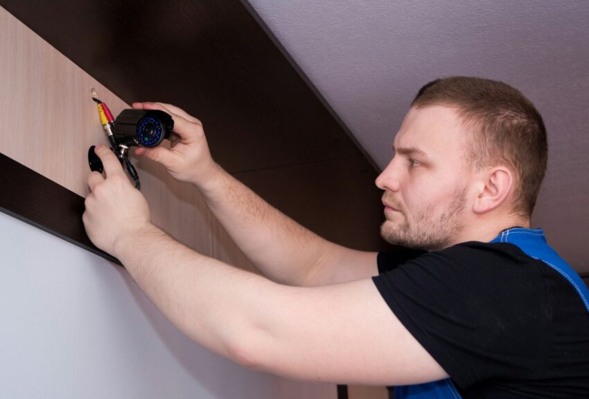 a man working on a wall with a screwdriver