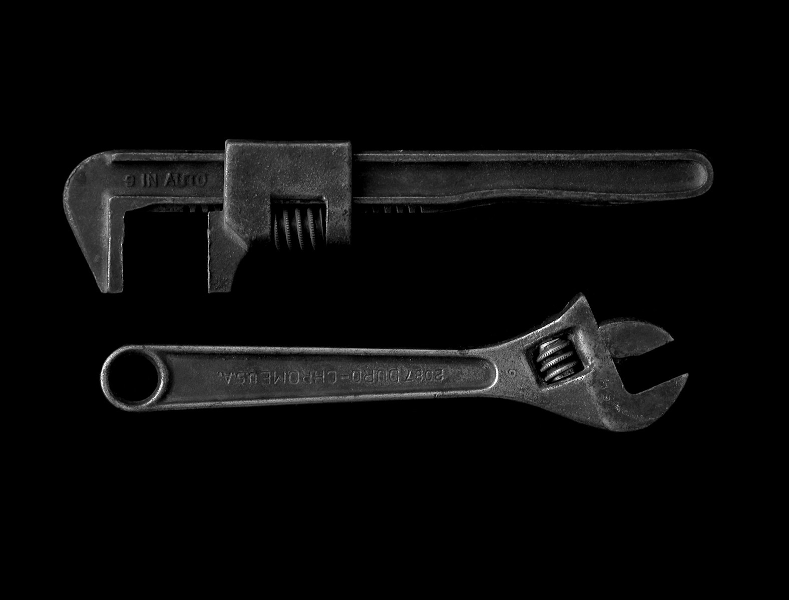 gray adjustable wrench and gray pipe wrench